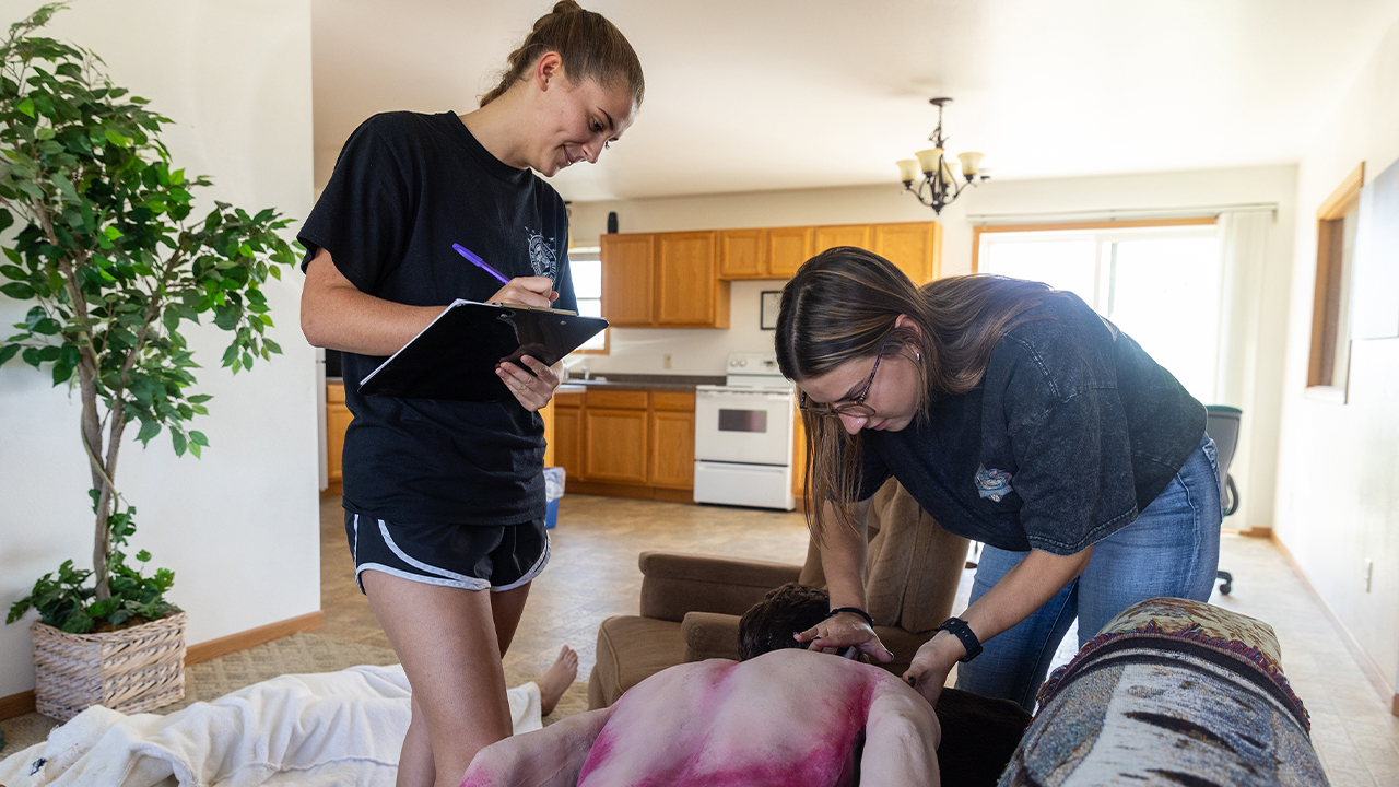 Students working with a new scene dummy at FICSH, equipped with thermo-chrome paint that simulates blanching livor mortis, conceived by Dr. Truesdell. 