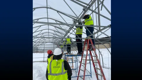Students erecting a greenhouse.