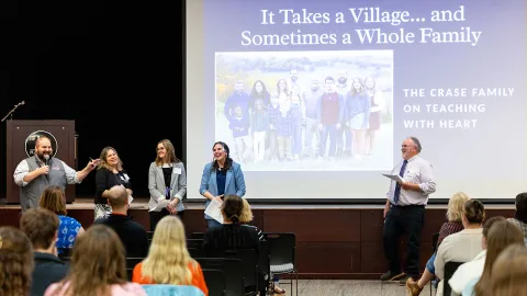 Group of presenters in front of a large screen