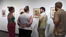 UW-Platteville Art Lecturer Jacob Bautista speaks with students about a print.