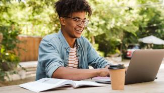 online student working outside on laptop