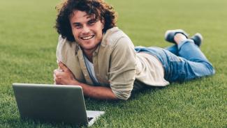 man outside working on laptop