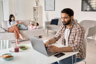 online student working with family in the background